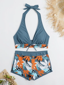 Dettaglio di slip bikini a vita alta con stampa tropicale e top con coulisse regolabile
