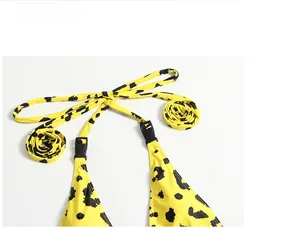 Detail of yellow leopard print bikini top with black buckle and halter neck straps