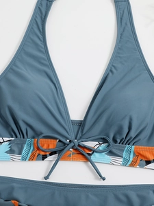 Dettaglio del top bikini blu navy a fascia con stampa tropicale e fiocco centrale