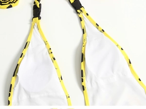 Detail view of yellow leopard print swimsuit with black plastic buckle and mesh lining