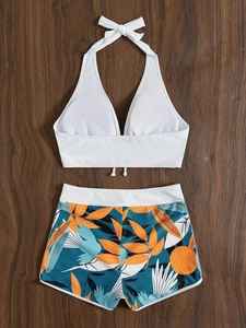 Top bikini bianco a fascia e pantaloncini da bagno con stampa tropicale su legno