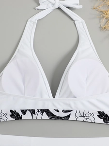 Detail of white halter bikini top featuring floral print edge and removable pads