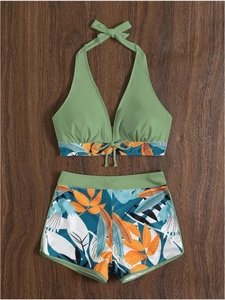 Dettaglio flat lay di un costume da bagno a due pezzi con stampa tropicale su legno