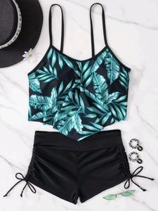 Flat lay of tropical palm leaf ruffled bikini top and high waisted drawstring swim shorts