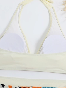 Dettaglio del top bikini bianco con imbottitura interna e stampa di foglie tropicali