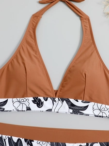 Detailed flat lay of a halterneck bikini with brown top and floral print trim details