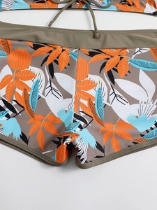 Dettaglio slip bikini a vita alta con stampa tropicale e cintura verde militare