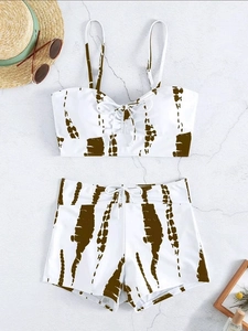 Flat lay of tie-dye high-waisted bikini set with drawstring details and summer accessories