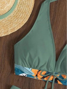Dettaglio del top bikini verde oliva con bordo a stampa tropicale e coulisse