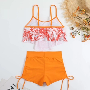 Detail of high waisted two-piece swimsuit with tropical leaf print and ruffles