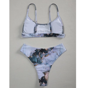 Flat lay of tie-dye bikini with marble print in glacier blue and gold textures