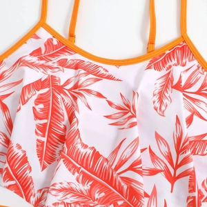 Detail of ruffle neckline on white bikini top with orange tropical palm leaf print