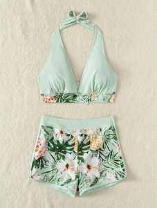Top bikini allacciato al collo verde menta e pantaloncini da nuoto con stampa floreale