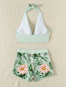 Dettaglio del bikini a fascia verde menta e pantaloncini con stampa tropicale