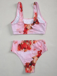 Detailed flat lay of pink marble print high-waisted bikini set on a textured fabric