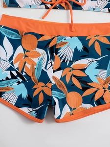 Dettaglio slip bikini con stampa tropicale, coulisse e motivo a foglie arancione brillante
