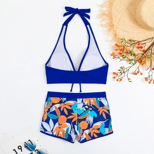 Dettaglio del top allacciato al collo e slip a pantaloncino con stampa floreale