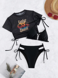 Detail of three-piece black bikini set with high-waist bottoms and mesh cover-up top