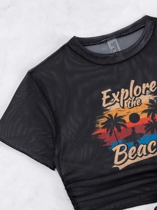 Detail view of sheer black mesh top with beach sunset print and material care label