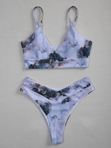 Flat lay of blue and purple marble tie-dye bikini set with gold vein detail and V-neck