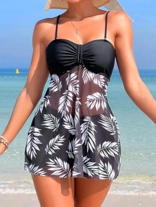 Detailed view of women's tankini with white leaf print mesh skirt and black bikini set