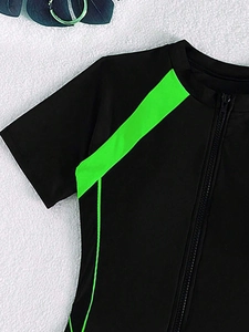 Detail of a black one-piece swimsuit with neon green stripes and front zipper closure