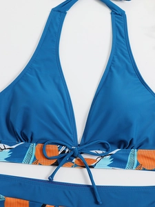 Dettaglio del top bikini blu navy con fascia a stampa tropicale e fiocco sulla parte anteriore