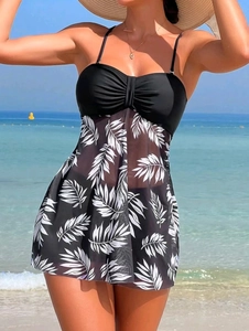 Detail of high waisted tankini featuring black top and white palm leaf mesh skirt
