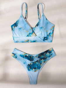 Flat lay of light blue marble print bikini set with V-neck top and matching bottoms