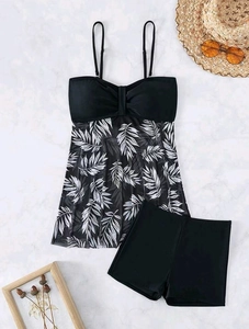 Flat lay of a two-piece tankini set with palm leaf print and high waisted boy shorts
