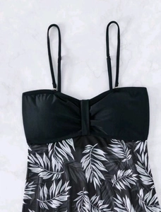 Detail of high waist tankini top featuring black satin bow and tropical palm leaf mesh