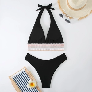 Flachbild von schwarzem Bikini-Set mit bunten Streifenband und Strandurlaub-Accessoires