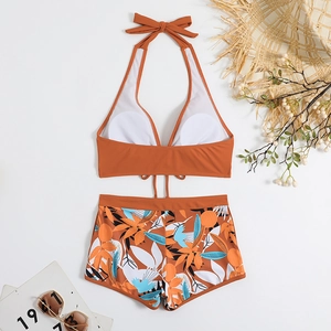 Dettaglio del top bikini allacciato al collo e pantaloncini a vita alta con stampa