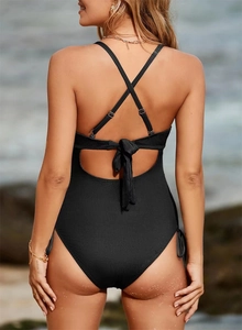 Back view of black ribbed one-piece swimsuit featuring cross-straps and tie-back details