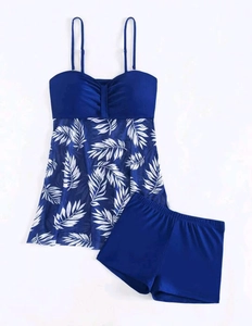 Detail of high waist tankini swimsuit with white leaf prints and blue boyleg swim shorts