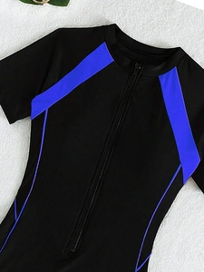 Close-up of front zipper and blue geometric splicing on black short-sleeve swimsuit