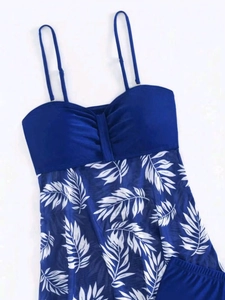 Detail of navy tankini top featuring adjustable straps and white leaf pattern mesh fabric