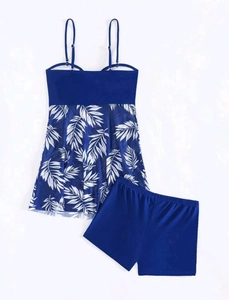 Detail view of two-piece tankini set featuring palm leaf print top and navy boy shorts