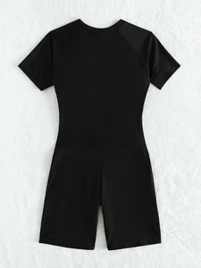 Detail of black short sleeve one-piece swimsuit with round neck on white fur background