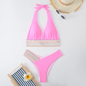Flachbild von pinkem Bikini mit bunten Webkanten, Sonnenbrille und Strandzubehör