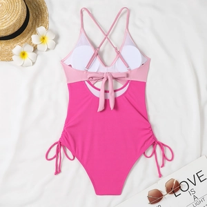 Detail of pink ribbed swimsuit with lace-up back and side drawstrings on summer beach decor