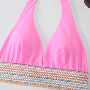 Detail eines rosa Halter-Bikini-Oberteils mit buntem Wellen-Gummiband und einer Sonnenbrille