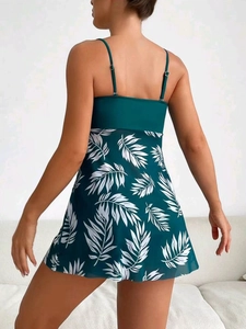 Detailed back view of a dark green tankini swim dress with white tropical leaf prints