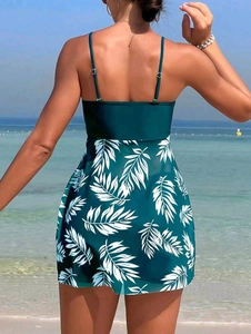 Rear view of dark green tankini swimsuit with white tropical palm leaf patterns on beach