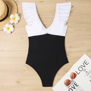 Detail view of V-neck one-piece swimsuit with white ruffles and black high-waist bottom