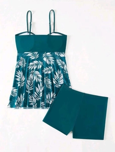 Flat lay of high waist tankini swimsuit with palm leaf print top and teal boy shorts