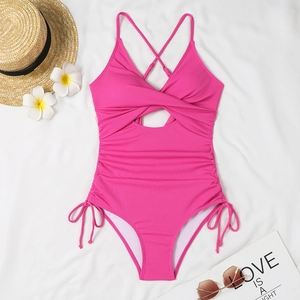 Close-up of bright magenta one-piece swimsuit with ribbed texture and drawstring details