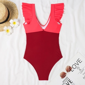Close-up of a deep V-neck one-piece swimsuit with red color blocking and ruffle straps