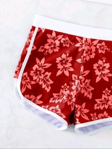 Detail von High-Waist-Schwimmshorts mit tropischem Blumenmuster und weißer Paspelierung
