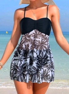 Detail of elegant black swimdress bodice with ruched gather and palm leaf skirt